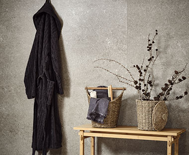 Черен халат за баня, закачен на стената.