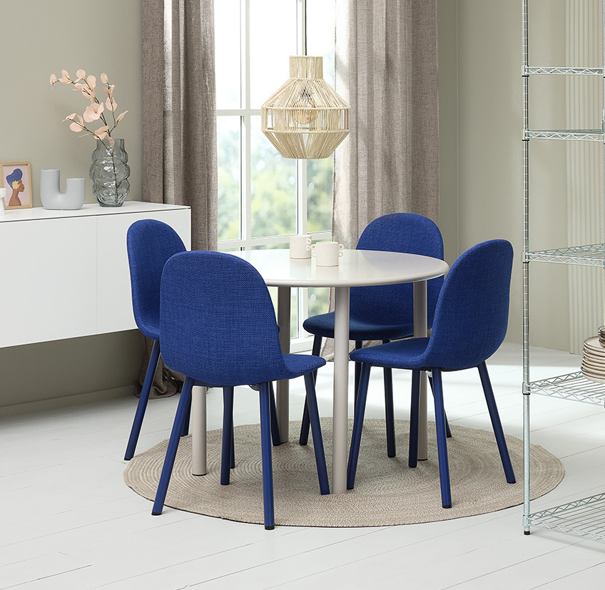 Стол за хранене в кобалтово синьо и кръгла маса за хранене в бяло.