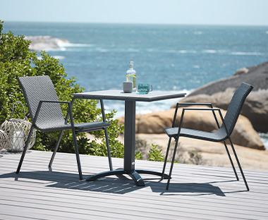 Градински комплект от маса и столове на слънчева тераса.