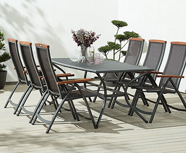 Градински комплект от маса и столове на слънчева тераса.