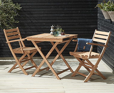 Дървени градински маса и столове на слънчева тераса.