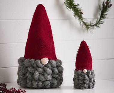 Коледен елф с червена шапка и гъста сива брада.