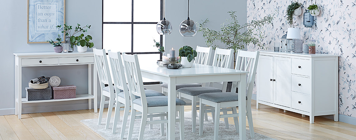 Трапезария с мебели в бяло – конзолна маса, кухненска маса, кухненски столове и бюфет.