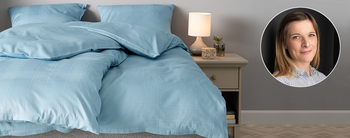 Легло със спално бельо в цвят петрол.