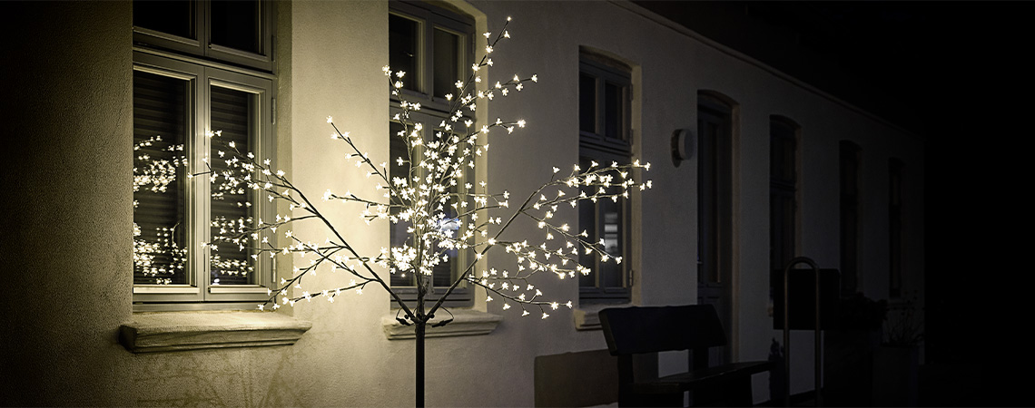 Светещо LED дръвче пред дома през зимата.