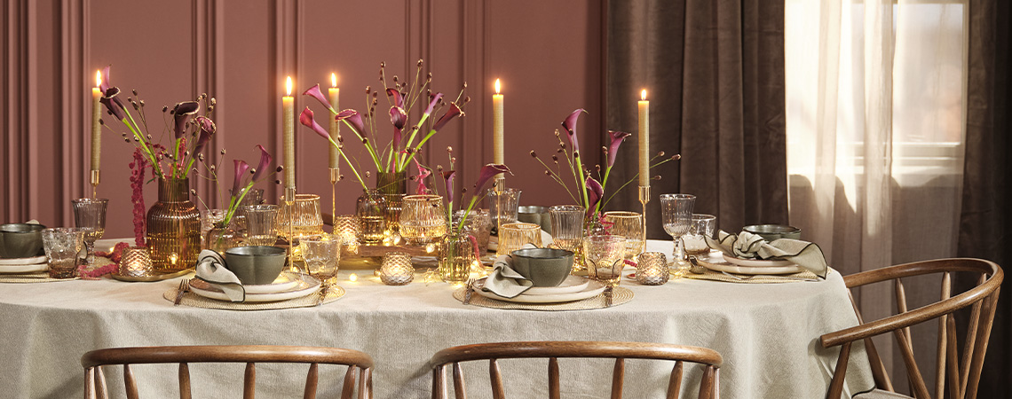 Коледна аранжировка на масата с тематични артикули, които приветстват празниците Празнична коледна аранжировка на масата с наситени цветове като бордо, зелено и сиво