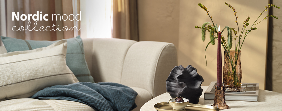 Всекидневна с диван и масичка за кафе със стъклена ваза и свещник