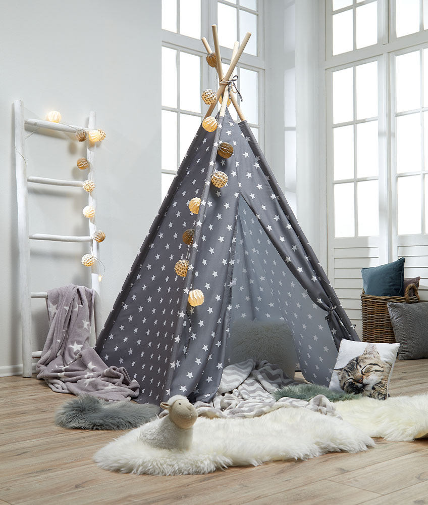Детска палатка за игра в сиво с бели звезди и уютни декорации.