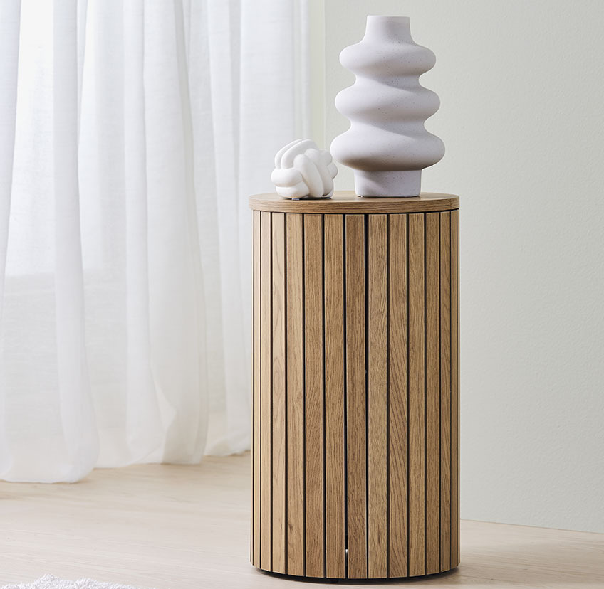 Дървена масичка от дъб с бяла ваза и скулптура.