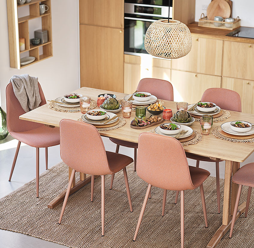 Tрапезни столове в цвят праскова около маса за хранене в дневната.