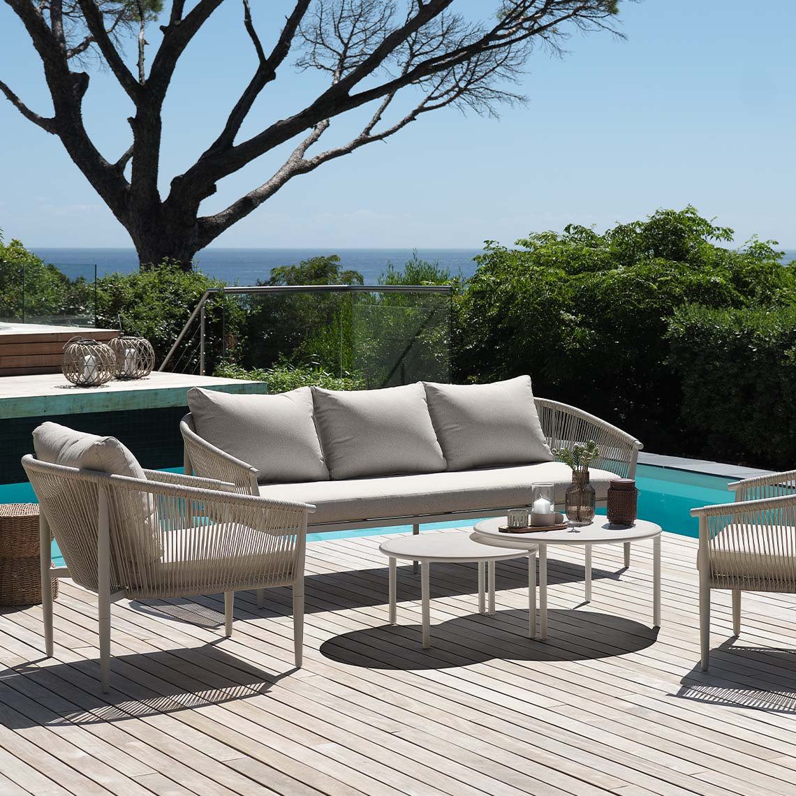 Bright beige, maintenance-free garden lounge set on patio by pool 