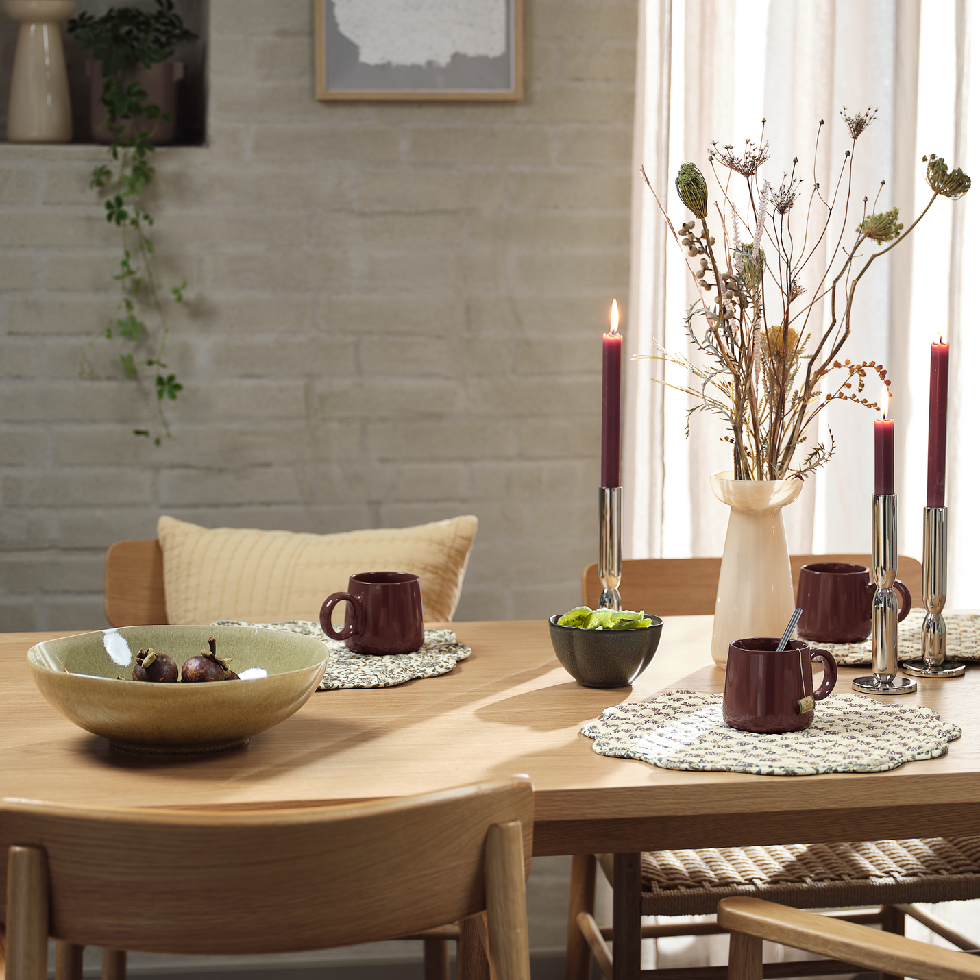 Стилно подредена маса с купа, чаши, свещници и ваза с цвете