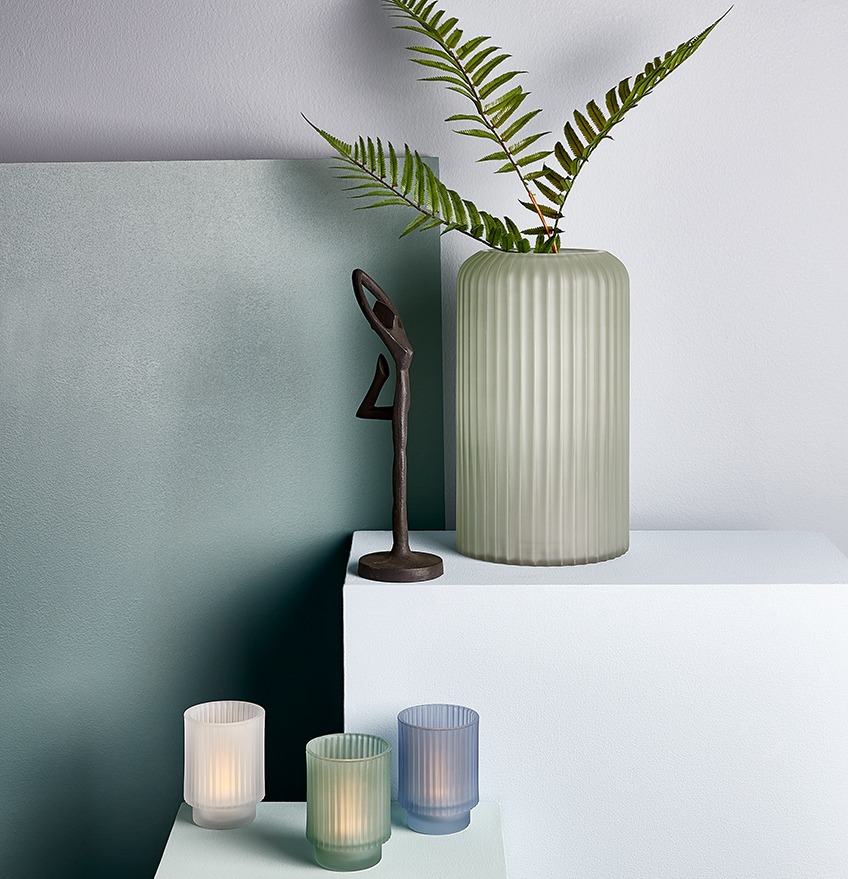 Black ornament, tealight holders and vase with artificial plant, in dusty blue and green colours