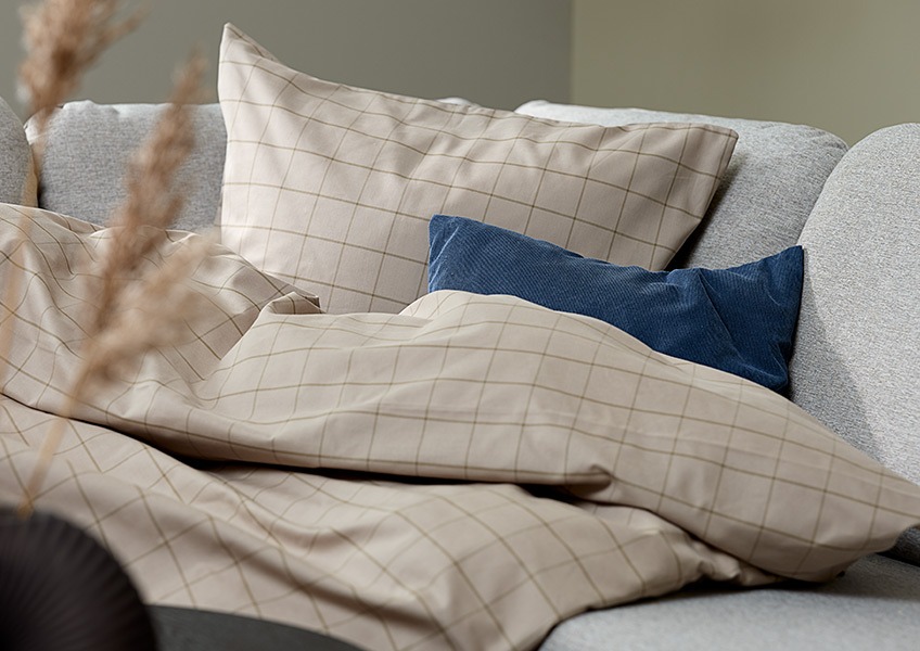Завивка и възглавница облечени в красиво спално бельо. 