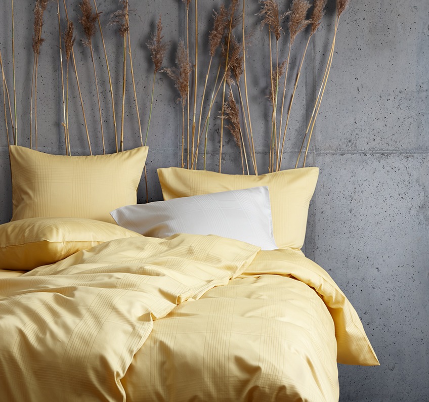 Спално бельо в жълто от 51% рециклиран полиестер и 49% памучен сатен.