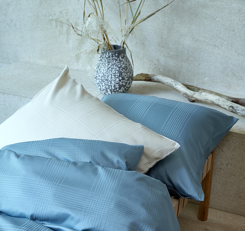 Възглавница и завивка с луксозно спално бельо в цвят петрол и пясък.