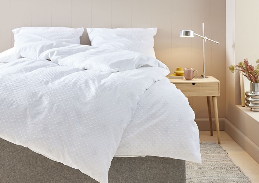 Легло с красиво минималистично спално бельо.