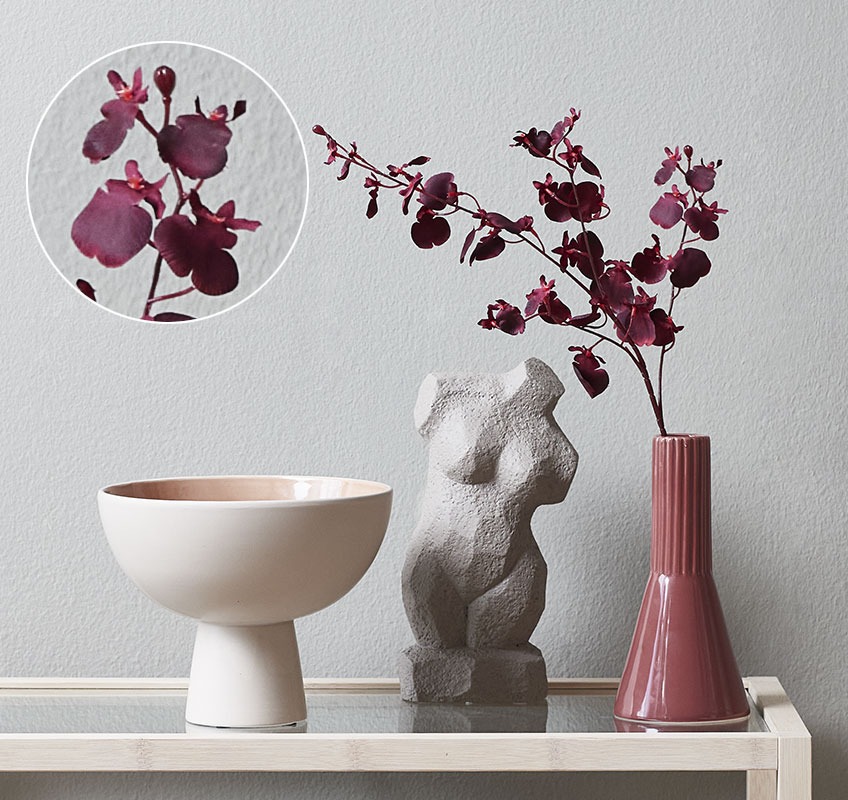 Малка ваза с изкуствено цвете орхидея и скулптура на женско тяло