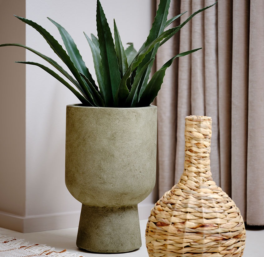 Зелена саксия с изкуствено растение до плетена ваза