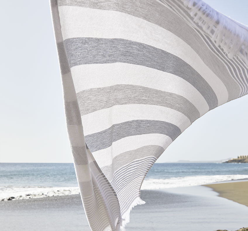 Раирана плажна кърпа, развявана от вятъра