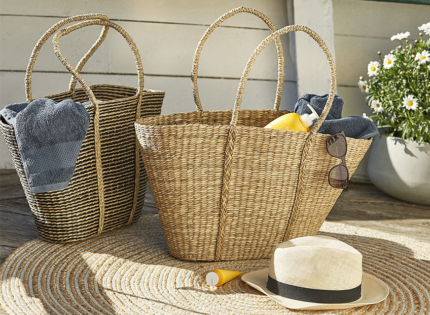 Две плетени плажни чанти със слънцезащитни продукти и кърпи